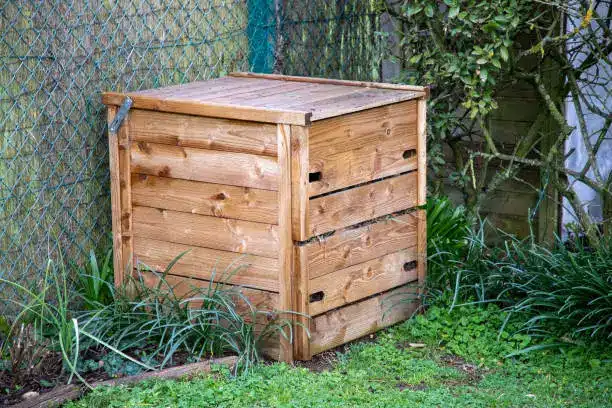 Un composteur en bois au fond du jardin