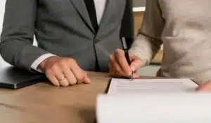 deux personnes en train de signer un papier