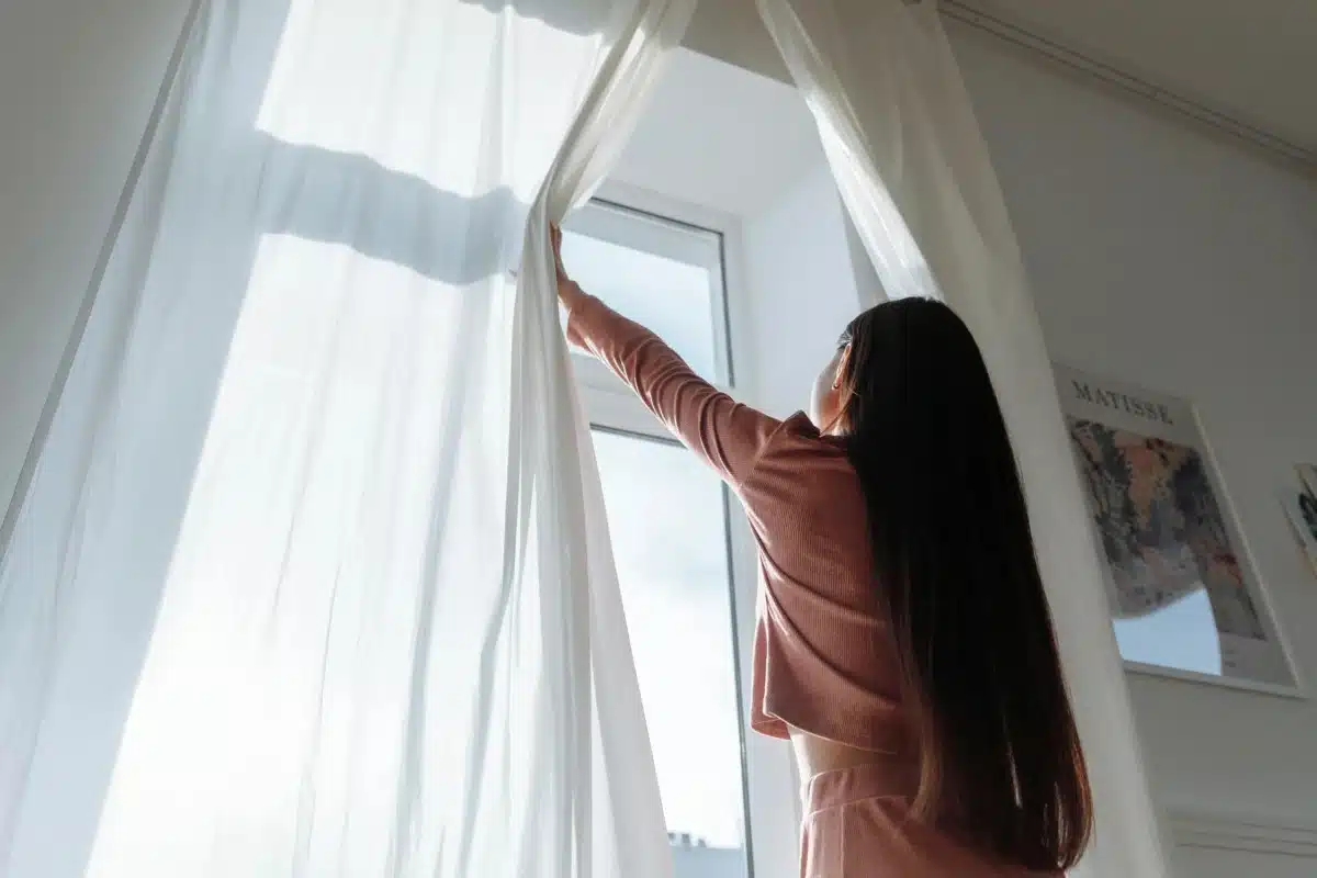Une femme qui ouvre sa fenêtre