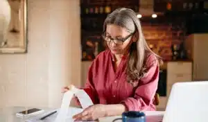 une femme sur son bureau qui consulte la taxe d'habitation