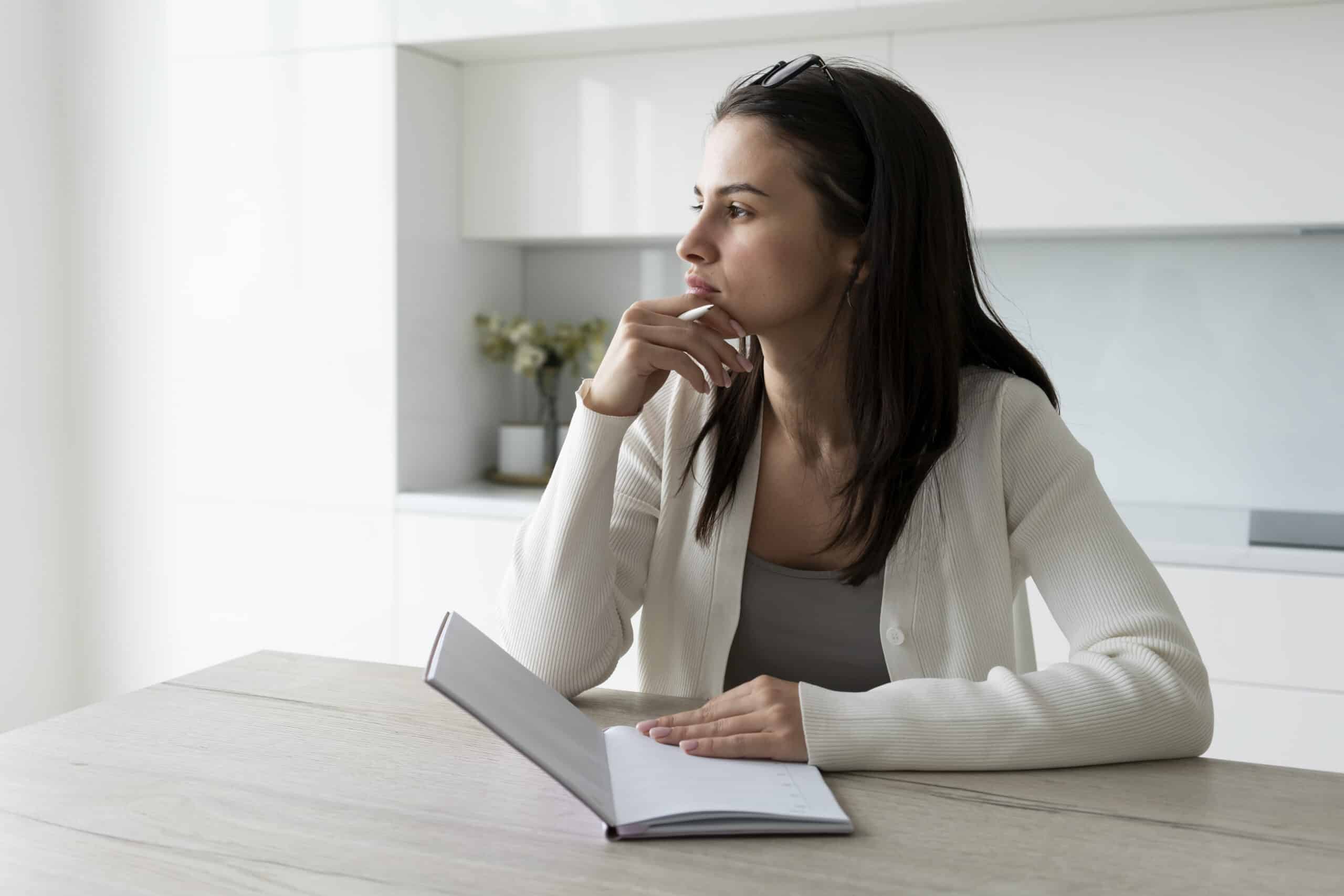 une femme pensive dans sa cuisine